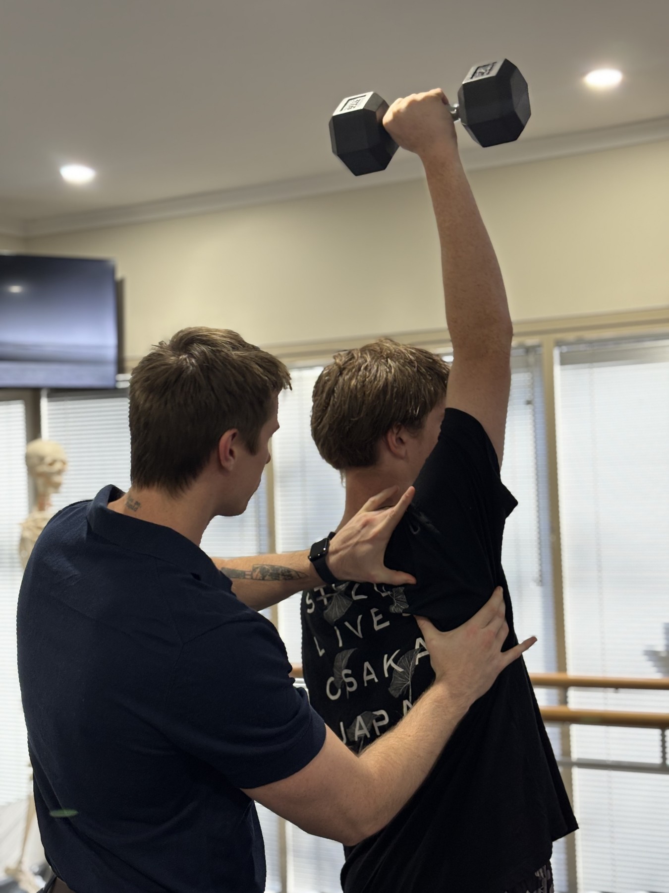 Physiotherapist guiding a patient through shoulder strength rehabilitation